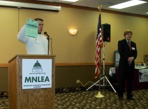 Rep. Mark Buesgens holds up the LEA 2012 report on the legislature. LEA President John Augustine standing to his left.
